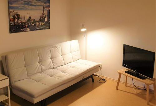 un sofá blanco en la sala de estar con TV de pantalla plana en Tihase studio apartment with sauna, en Tallin