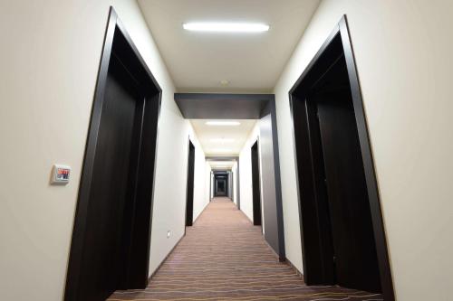 a corridor of a hallway with black doors at Hotel Galaxy in Timişoara