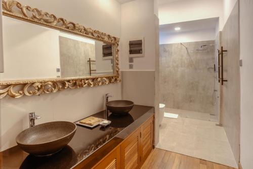 a bathroom with a sink and a mirror and a shower at The Postcard Galle in Galle