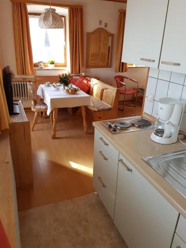 a kitchen and living room with a table and a couch at Brausamhof in Seeon-Seebruck