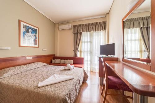 a hotel room with a bed and a desk at Lido Hotel in Katerini