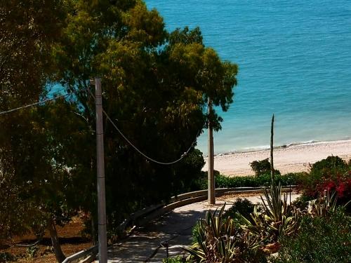 a path to the beach with trees and the ocean at Holiday Beach Lumia in Sciacca