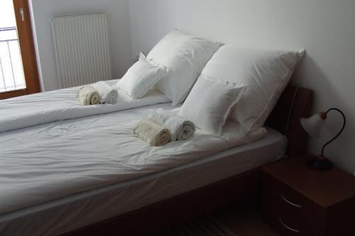 Una cama con almohadas blancas y toallas. en Central Pécs Free Parking en Pécs