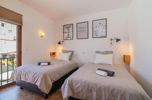 two beds sitting next to each other in a bedroom at H&H seaview in Luz