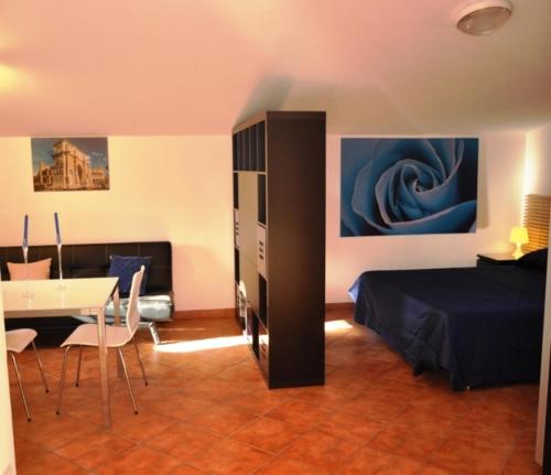 - une chambre avec un lit et une table avec des chaises dans l'établissement Villa Smeraldo Roma, à Infernetto