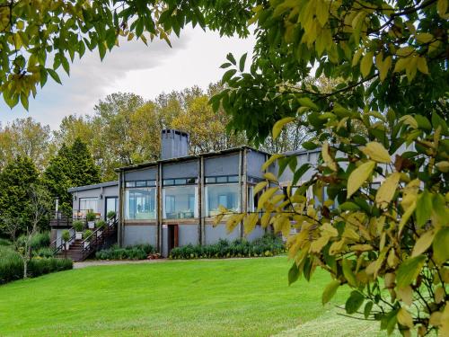 a house with glass windows and a lawn at Brahman Hills - Gardens, Hotel & Cottages in Nottingham Road