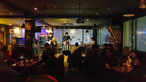 a group of people sitting in a bar with a band at Gangneung Guesthouse Myu in Gangneung