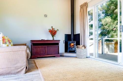 a living room with a couch and a wood stove at Brahman Hills - Gardens, Hotel & Cottages in Nottingham Road