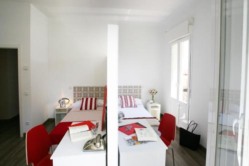 two beds in a room with red chairs at Estuhome in Madrid