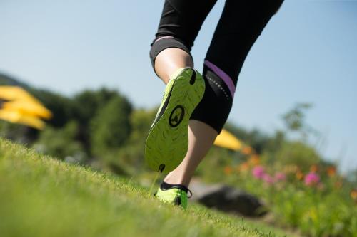a woman running down a hill with green shoes at Hotel Garni Toscanina - Adults Only in Bad Radkersburg