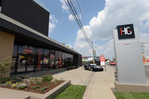 a sign in front of a building with a car dealership at Hotel Galaxy in Timişoara