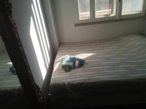 un orsacchiotto che giace su un letto in una camera da letto di Antichi Riflessi suite a Cagliari