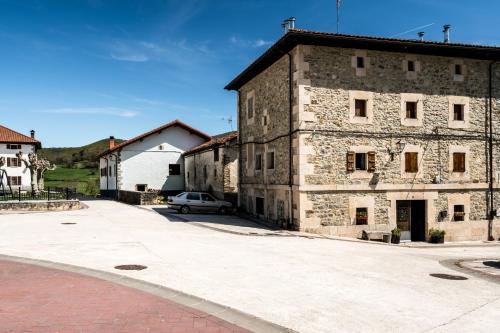 an old stone building with a car parked next to it at AT rural Erro Center in Erro