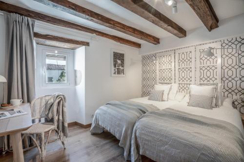 a white bedroom with two beds and a desk at AT rural Erro Center in Erro
