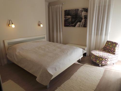 a bedroom with a bed and a chair at Apartments Rita in Lovran