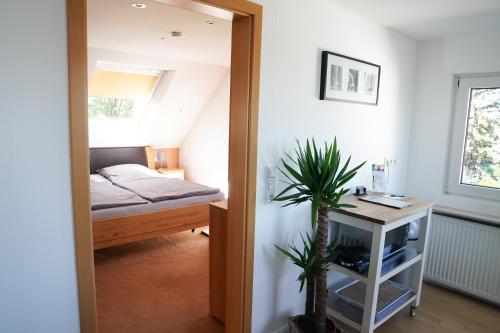 a bedroom with a bed and a table with a plant at Messezimmer Krefeld in Krefeld