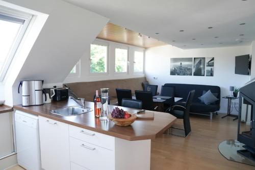 eine Küche und ein Wohnzimmer mit einer Theke und einem Tisch in der Unterkunft Messezimmer Krefeld in Krefeld