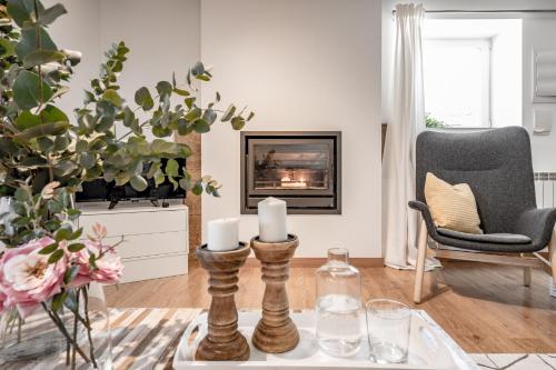 a living room with a fireplace and a table with candles at AT rural Erro Center in Erro