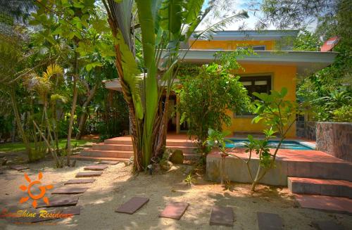 a house with a palm tree in front of it at Sunshine Residence in Baan Tai