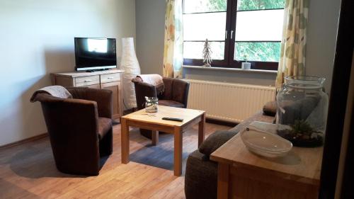 a living room with two chairs and a tv at Ferienwohnung Roeben in Simmerath