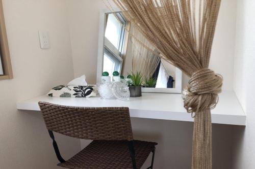 a desk with a chair and a window with a curtain at TerraceRin YN14 in Tomigusuku