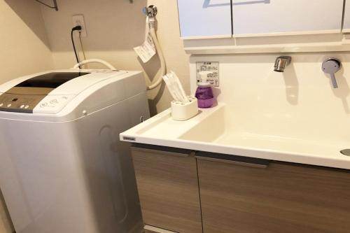 a bathroom with a sink and a washing machine at TerraceRin YN14 in Tomigusuku