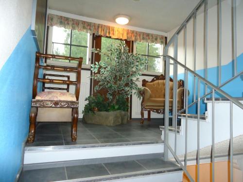 a room with a staircase with a chair and a plant at Hotel Lamminpää in Tampere