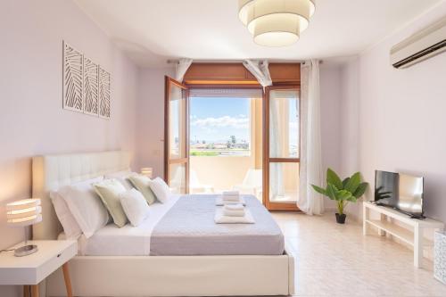 a white bedroom with a bed and a television at Residenze Su Planu in Cagliari