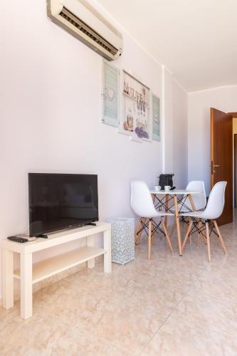 a living room with a tv and a table and chairs at Residenze Su Planu in Cagliari