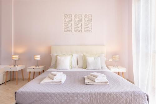 a white bedroom with a bed with two towels on it at Residenze Su Planu in Cagliari