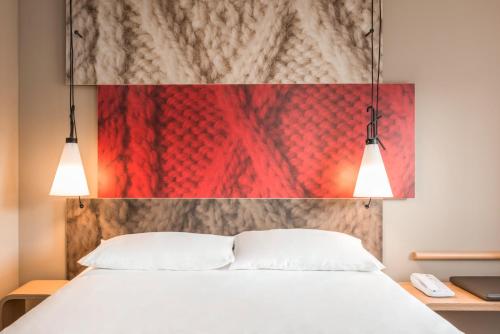 Una cama o camas en una habitación de ibis Gonesse Le Bourget