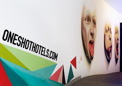 a wall with a sign that says one shooting season at One Shot Prado in Madrid