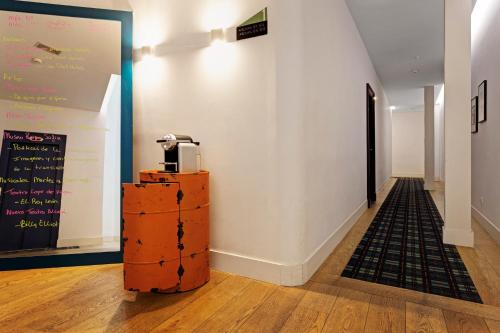 a hallway with a large white wall and a wall with a coffee machine at One Shot Prado in Madrid