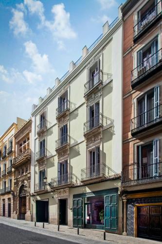 a white building with green doors on a street at One Shot Prado in Madrid