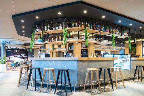 a bar in a restaurant with stools at ibis budget Gonesse in Gonesse