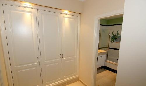 a bathroom with white cabinets and a mirror at Mogán suite in Puerto de Mogán