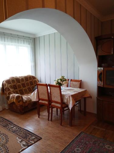 a dining room with a table and chairs and a couch at Rubina Bed and Breakfast in Tatʼev