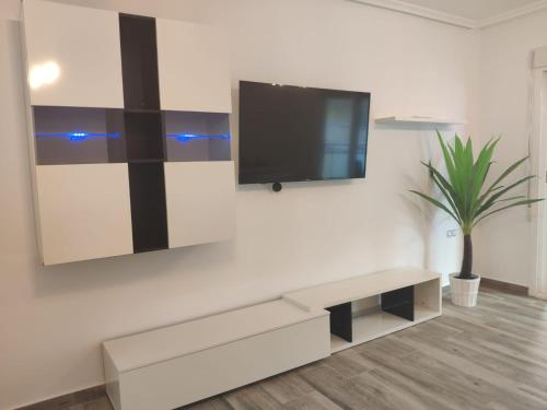 sala de estar con TV en la pared en Piso recien reformado a menos de 50m de la playa, en Torrevieja