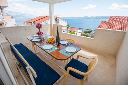 een tafel en stoelen op een balkon met uitzicht op de oceaan bij Apartments PIVAC - Lokva Rogoznica in Lokva Rogoznica