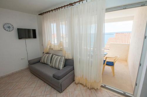 a living room with a couch and a window at Apartments PIVAC - Lokva Rogoznica in Lokva Rogoznica