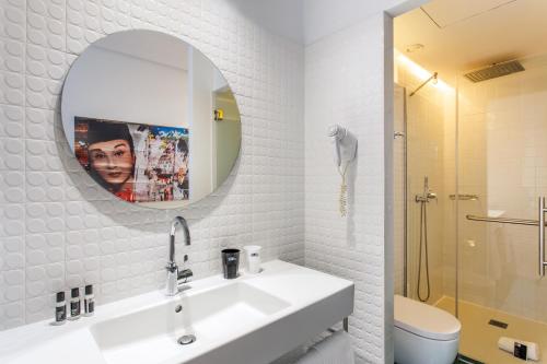a white bathroom with a sink and a mirror at One Shot Prado in Madrid