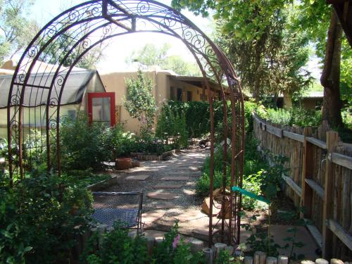 a garden with a metal gate and a path at The Historic Taos Inn in Taos