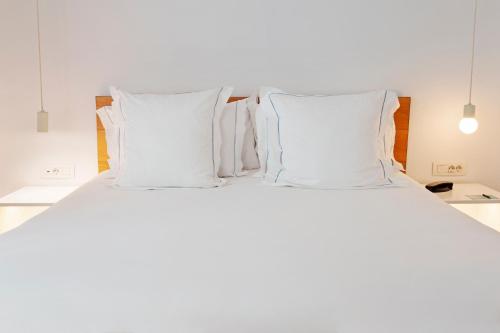 a white bed with white pillows in a bedroom at One Shot Prado in Madrid