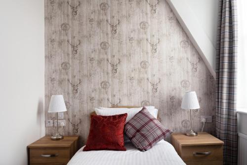 a bedroom with a bed with two lamps on night stands at The Lakeland Kendal Hotel, Sure Hotel Collection by Best Western in Kendal