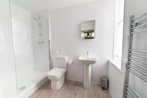 a white bathroom with a toilet and a sink at The Lakeland Kendal Hotel, Sure Hotel Collection by Best Western in Kendal