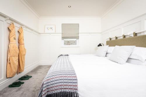 a bedroom with a large bed with white walls at Galgorm in Ballymena