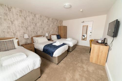 a hotel room with two beds and a flat screen tv at The Lakeland Kendal Hotel, Sure Hotel Collection by Best Western in Kendal