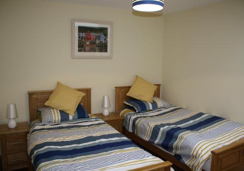 duas camas sentadas uma ao lado da outra num quarto em Callie's Cottage em North Berwick