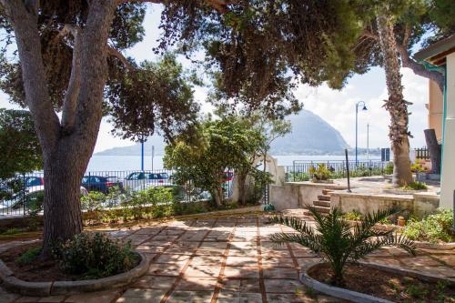a sidewalk with a tree and a mountain in the background at Villa Mallandrino in Mondello