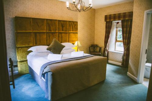 a bedroom with a bed with white sheets and pillows at Galgorm in Ballymena